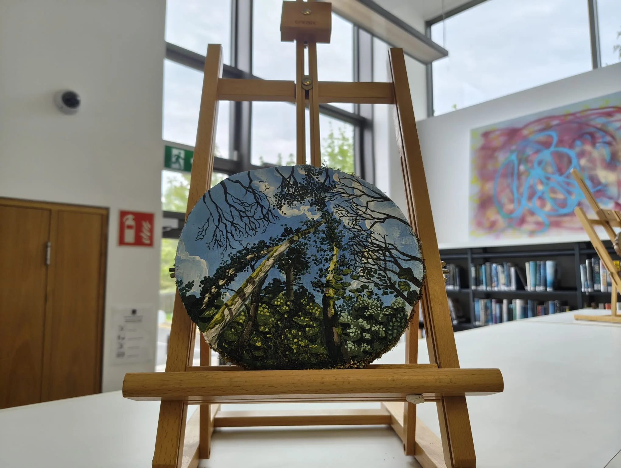 Painted wood disc on an easel at the Topography exhibition