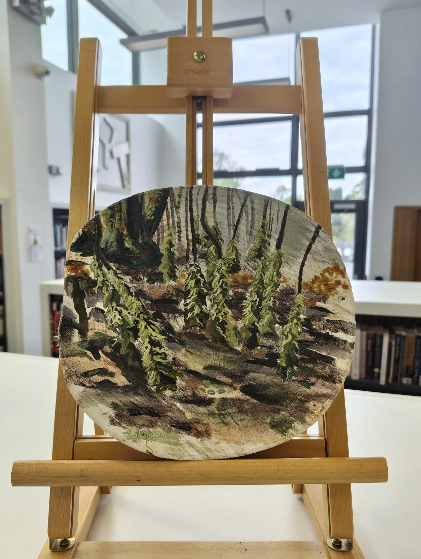 Painted wood disc on an easel at the Topography exhibition